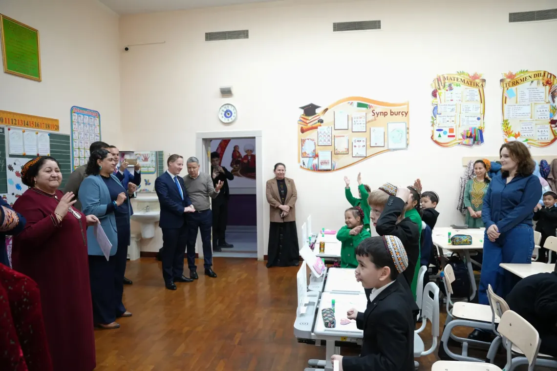 Officials are interacting with children in the classroom