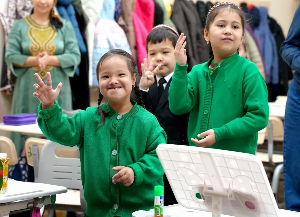 a photo of children smiling and looking at the camera