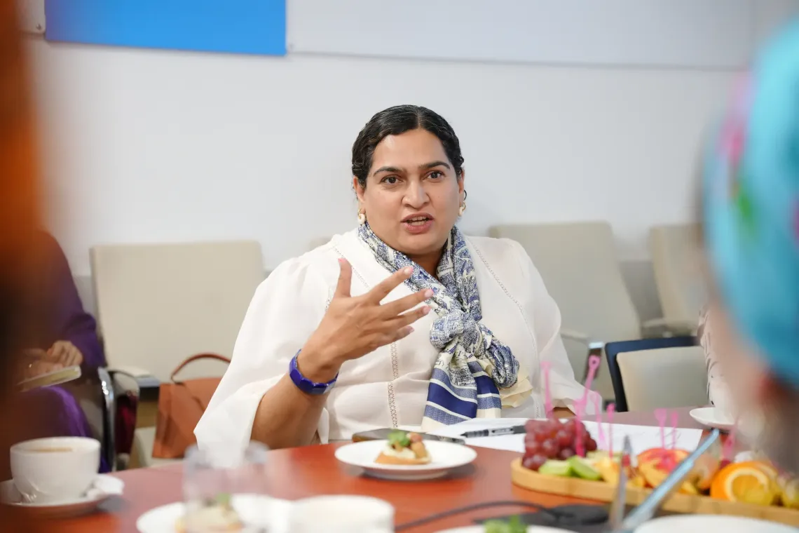UNICEF Representative Jalpa Ratna speaking with hand gestures during a roundtable meeting seated at a conference table.