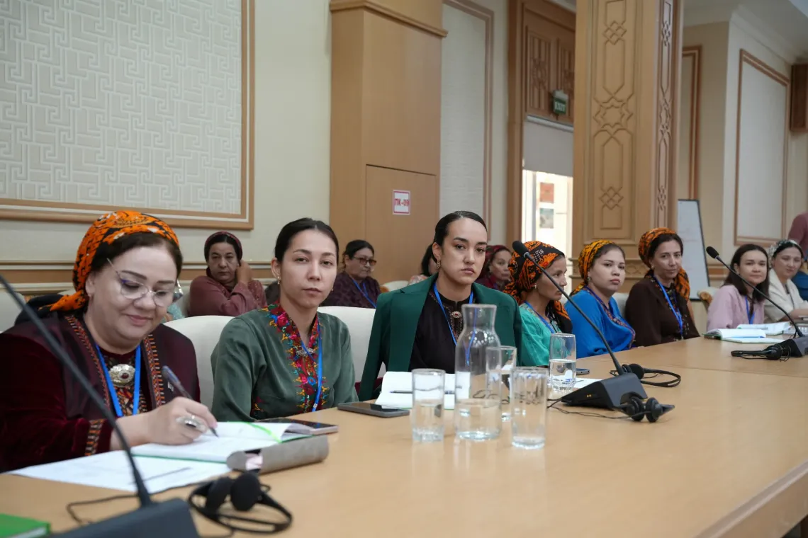 Education specialists and teachers seated at a long conference table taking notes during an inclusive education technical meeting.