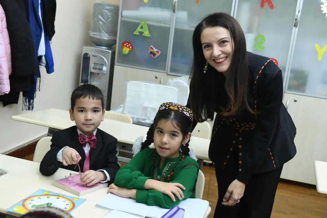 A boy, a girl and a woman looking at the camera