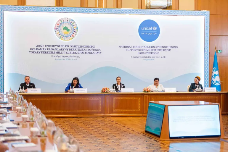 The main panel of speakers seated at the front of the stage under large backdrop banners for UNICEF and the Charity Fund.
