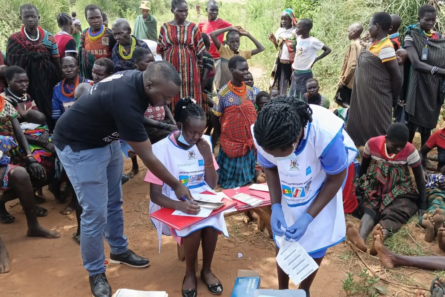 Health workers register children and prepare vaccines during an integrated outreach in Kotido District, where families gather for nutrition screening, treatment and immunisation. The outreach is supported by UNICEF and the Government of Uganda with funding from the Uganda Humanitarian Fund managed by OCHA.