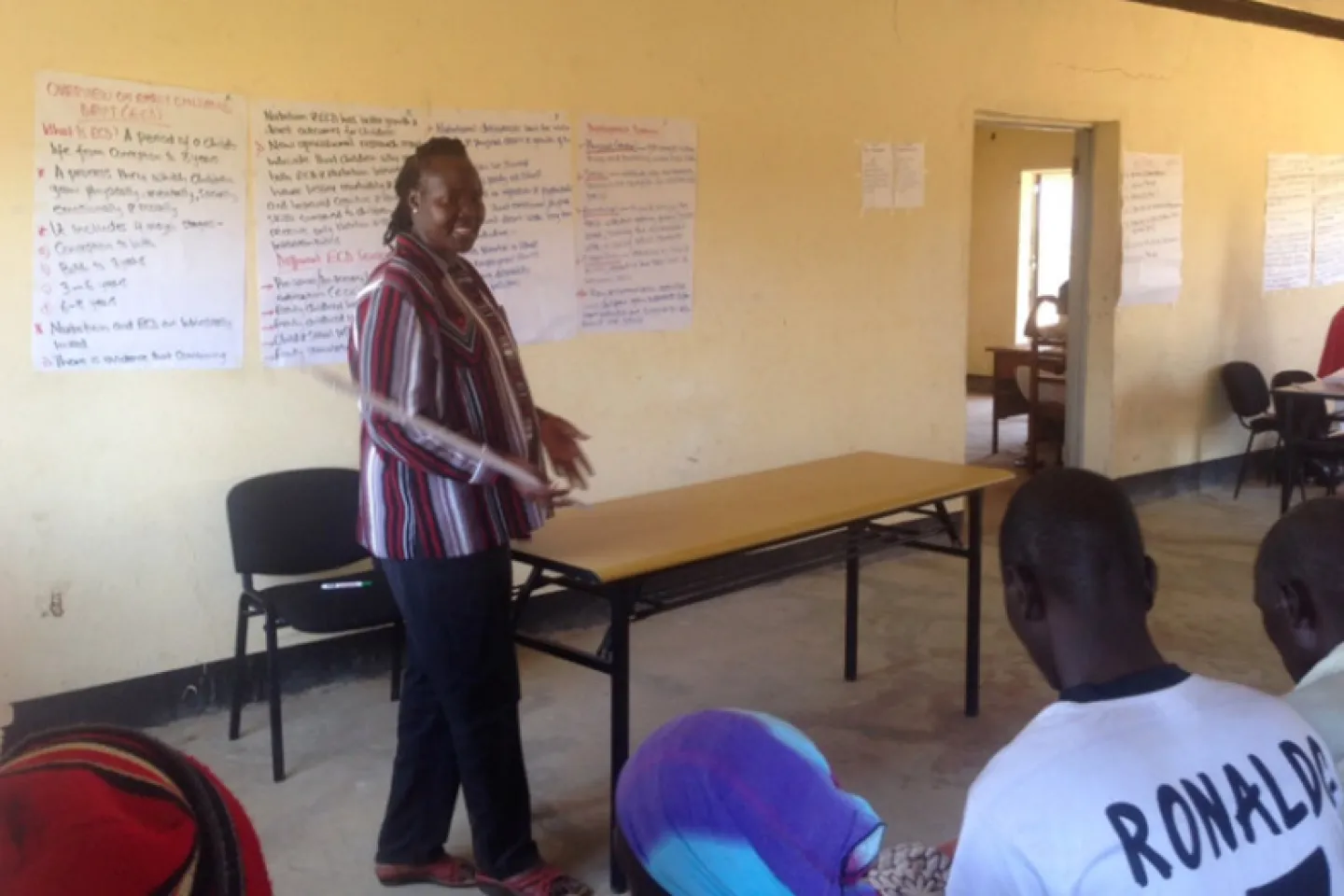 A woman stands in front of a class