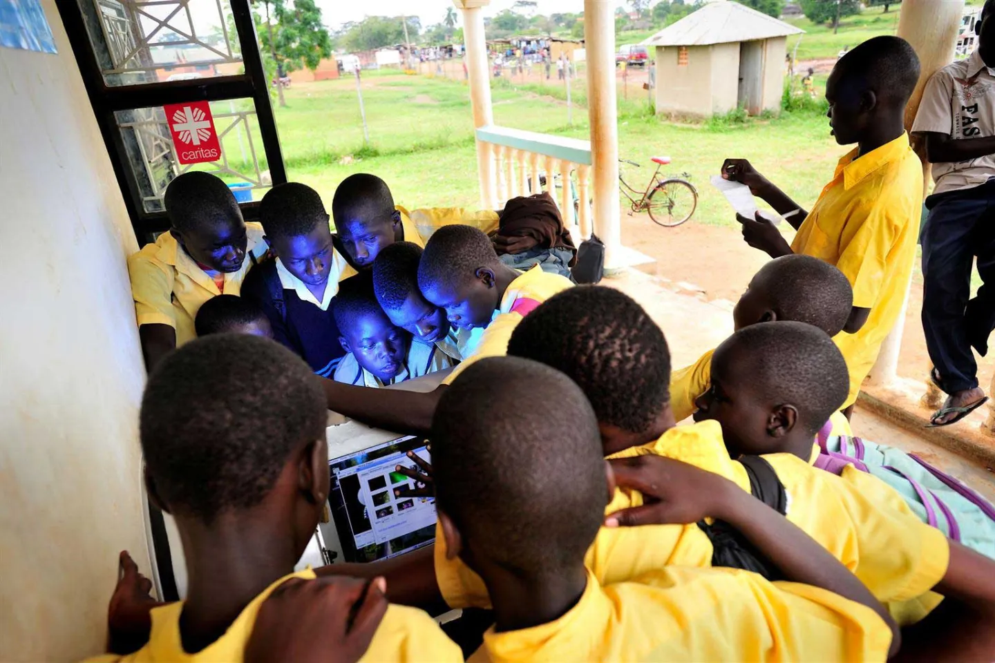 Groups of children huddled around computers