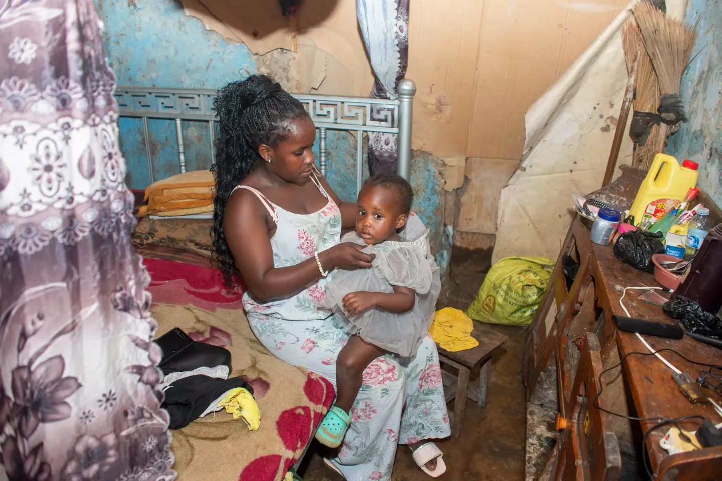 Esther Wema, 16, a teenage mother looking after her two-year-old daughter Amira Jemima inside her rented one - roomed house in Katanga Kampala