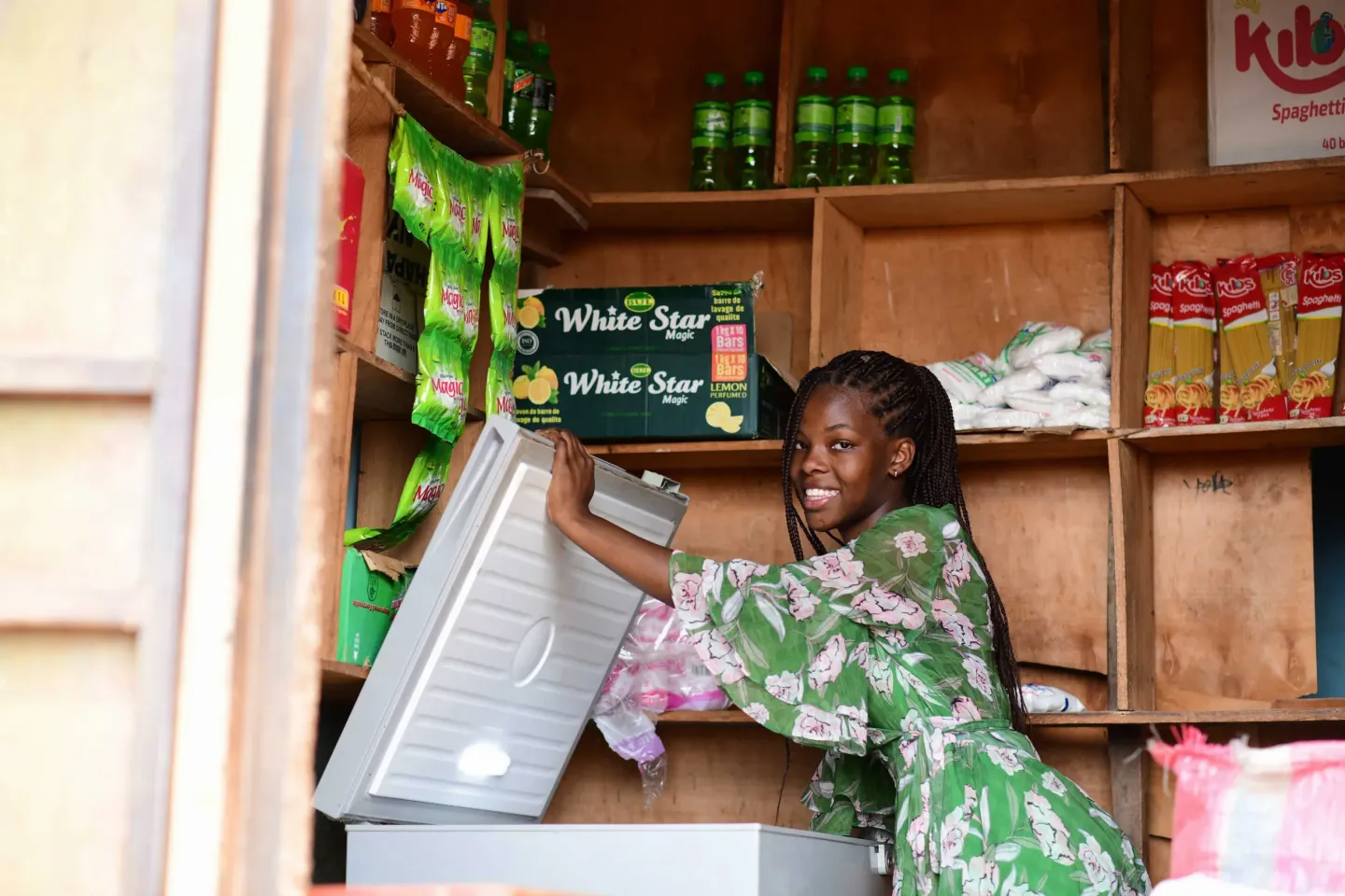Nineteen-year-old Masiga Gift Naome, one of the beneficiaries of the Girls Empowering programs attends to her family shop.