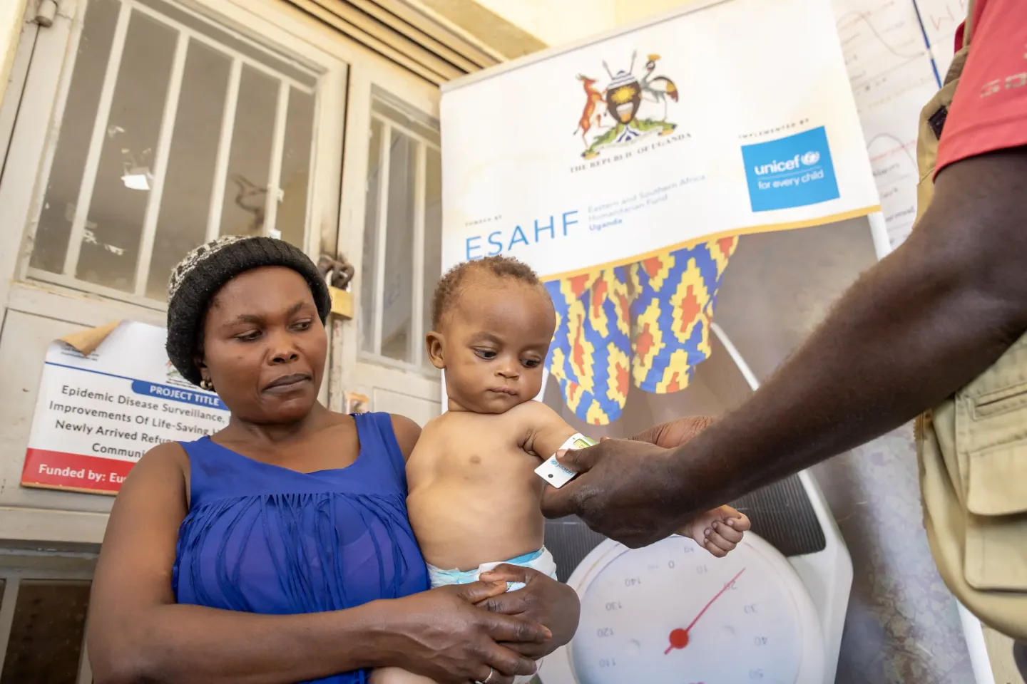 A child's mid-upper arm circumference is measured using a MUAC tape at Nyarugugu Health Centre in Nakivale Refugee Settlement, Isingiro District. The colour-coded reading shows whether a child is well-nourished or at risk, allowing health workers to identify malnutrition early and start treatment. The work is supported by the Uganda Humanitarian Fund, through UNICEF.