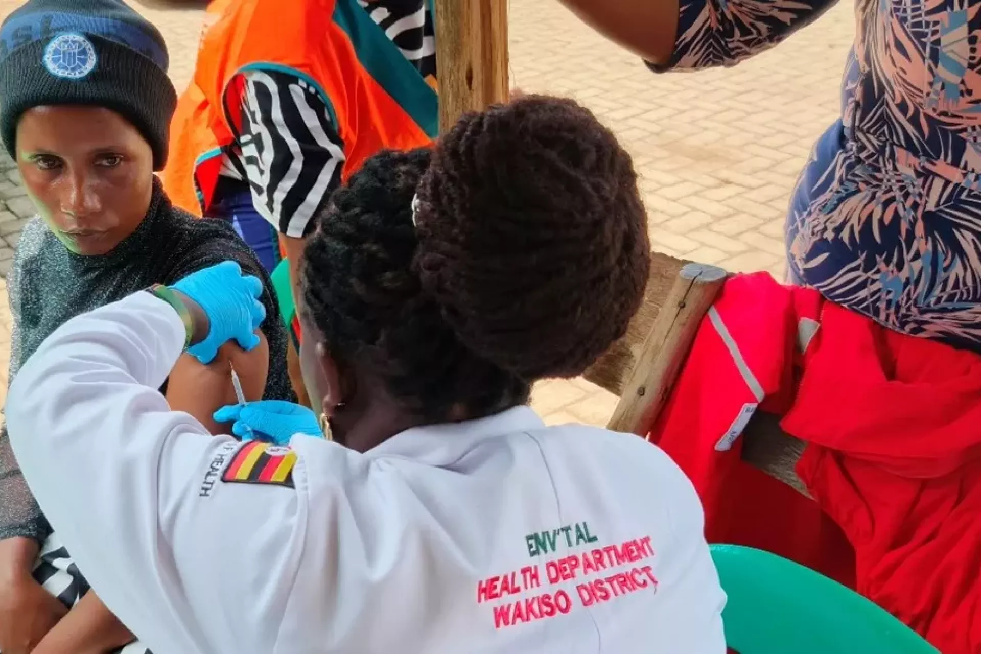 Rose Namirembe receiving mpox vaccine at Kigungu fishing community.