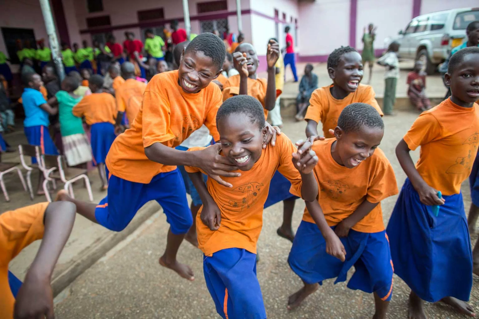 Group of boys in blue shorts and orange shirts