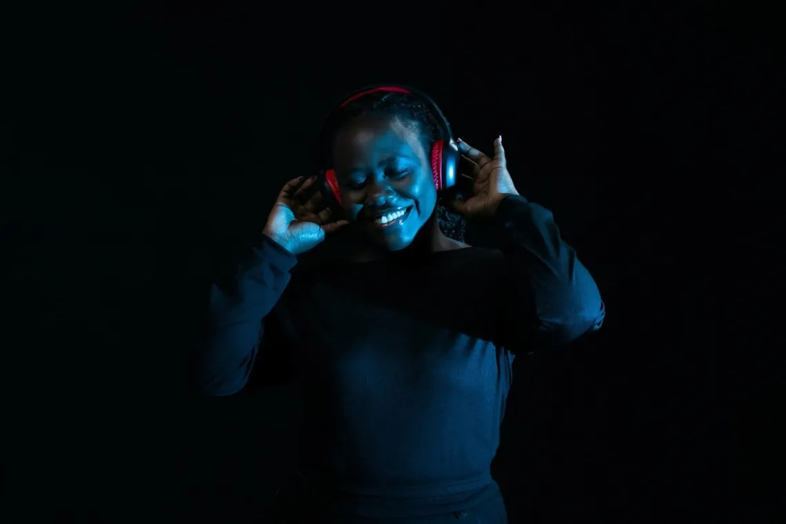 Victoria Wafula, with her headset and phone through which she finds joy in music. As U-Reporter, Victoria, 24, believes in three key ways to hasten understanding and acceptance of mental health issues in Uganda: use of the local language to create awareness; mandatory recruitment of mental health personnel in all schools; and training religious leaders to enable them to combine mental therapy and spirituality.