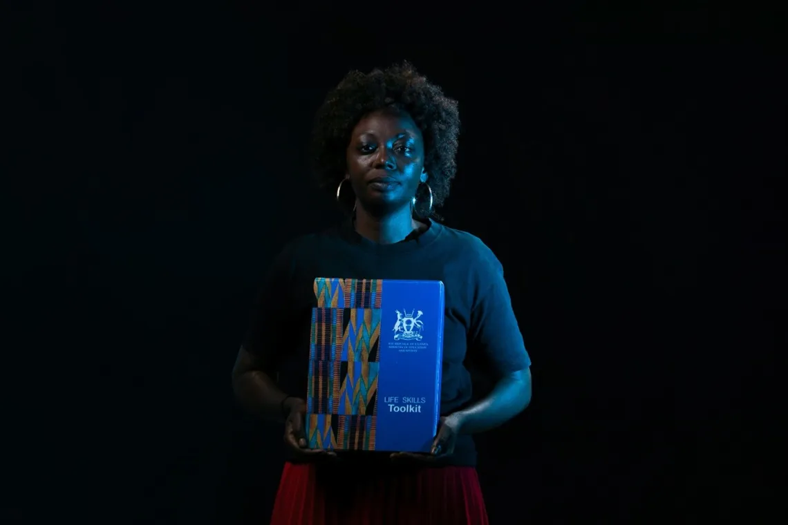 Primary School Teacher Rita Kabiira Peace holds a Life skills toolkit that she uses to help learners build Identity and self-esteem, as well as manage conflict and solve problems. Through activities like music and sports, the children open up and are able to make the right choices to stay in and complete school.