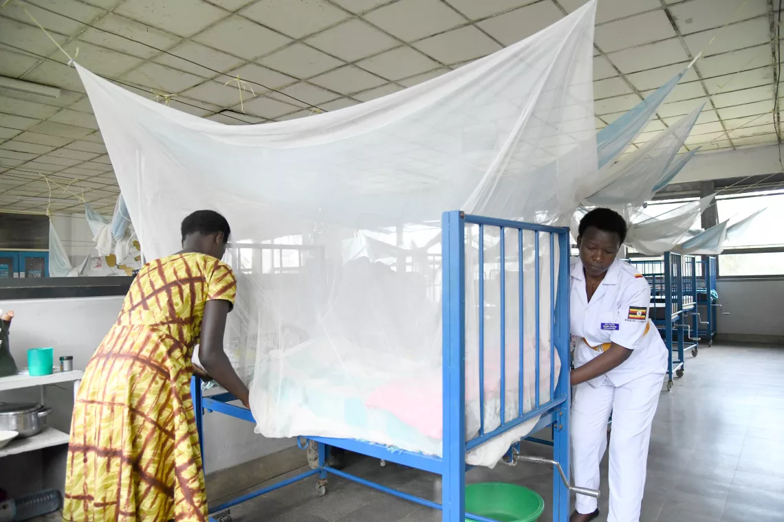 Aturinda Specioza enrolled nurse helping Niwareza Flavia tucking in the net to prevent mosquito bites in the pediatric ward at Itojo hospital in Ntungamo district.  UNICEF in partnership with ministry of health has been availing free mosquito nets to children and pregnant mothers to fight malaria. Picture taken on April 19, 2023. PHOTO BY MARIA WAMALA
