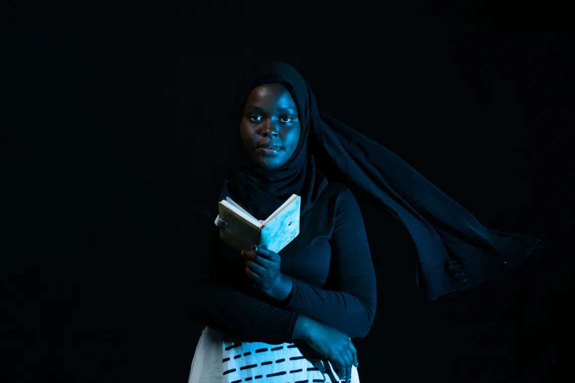 Hijirat Kaze cradling her journal. In a foreign land, with a new language and people, 20-year-old Hijirat reports feeling lost and forgotten as a refugee, until she journals. &ldquo;I write in my book. I write about my journey, behavior that I want to change and everything about me.