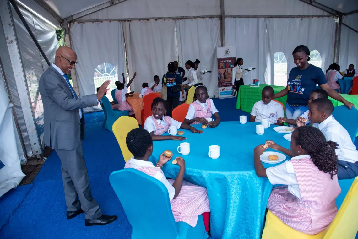 Dr. Munir Safieldin, the UNICEF Representative to Uganda, greets different groups of children within the hubs, as they had breakfast, prior to their beginning the day&rsquo;s activities.
