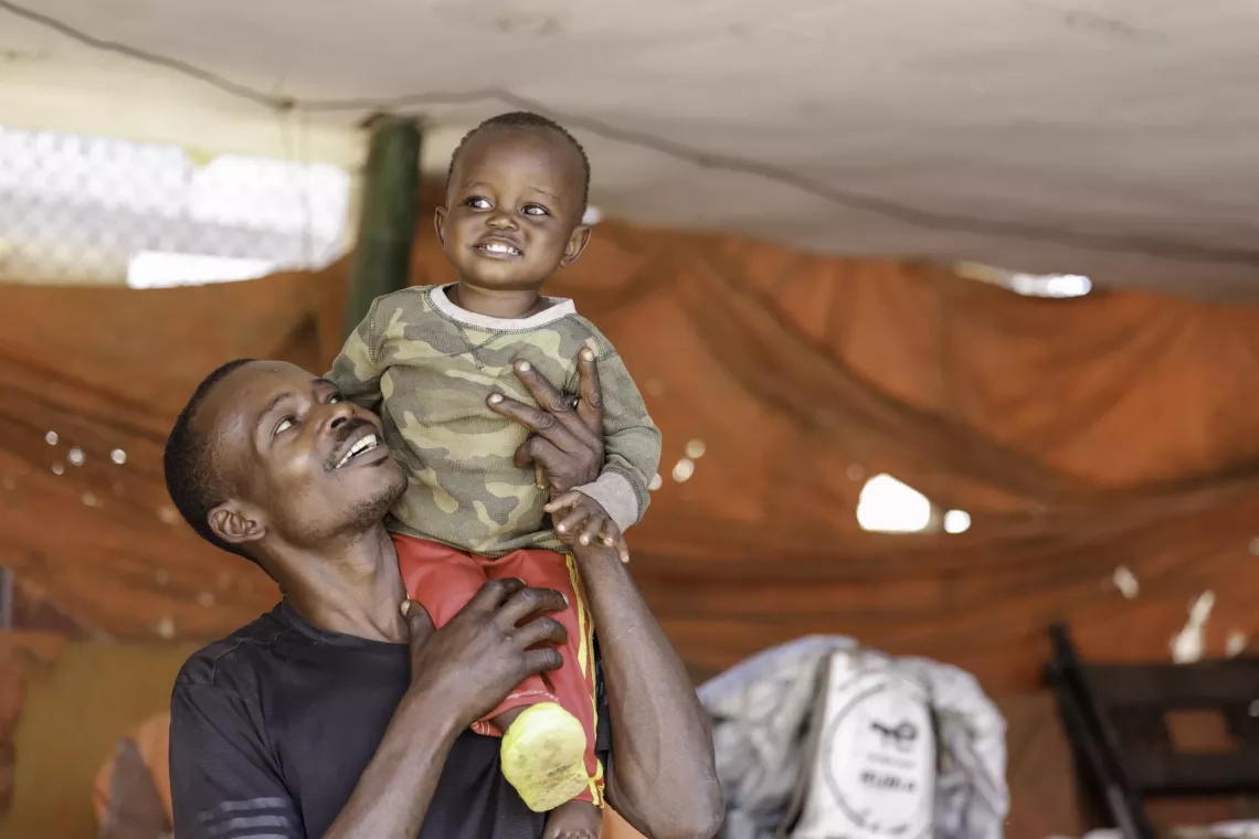 Byakatonda Francis, 29, plays with his 16-month-old son Joel in Rubaga, Kampala. Joel had never been immunized as his parents had moved to their village in Rakai at his birth and relocated to Kampala later on.