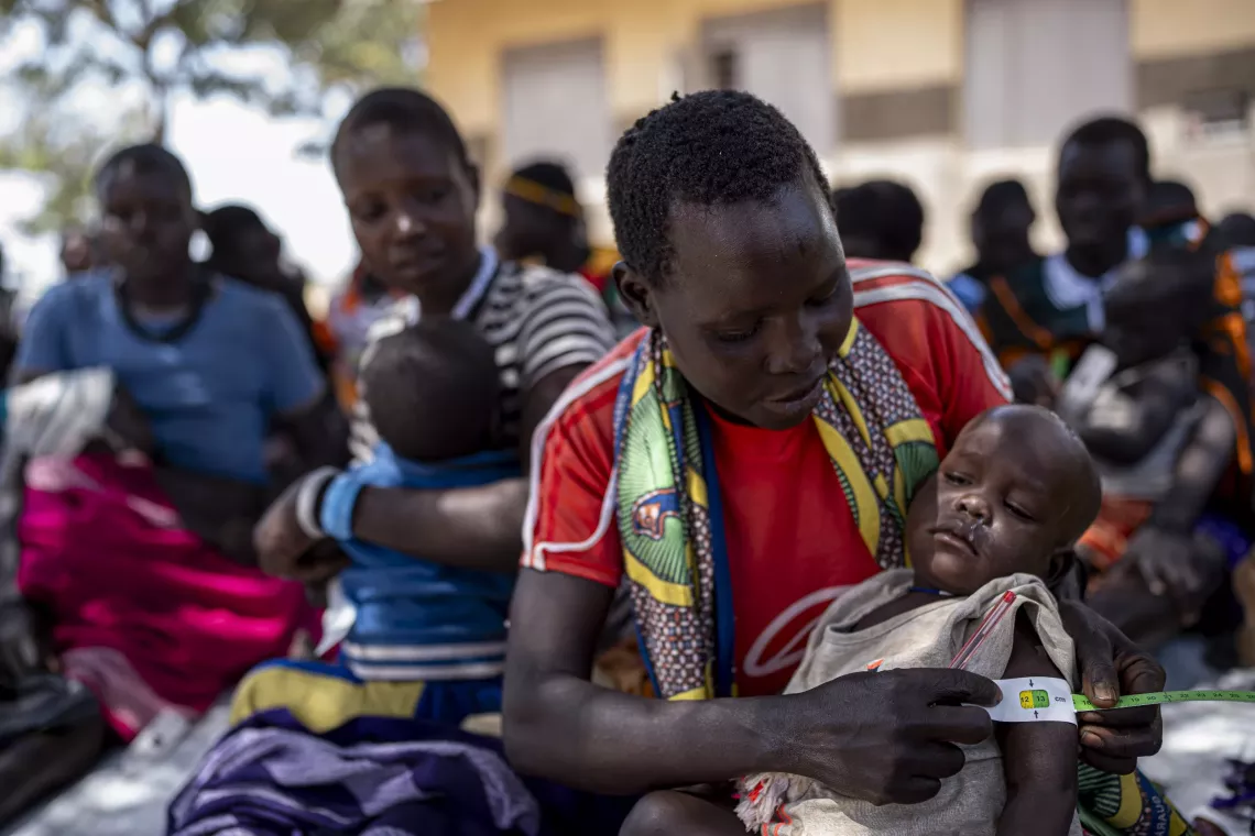 Lochlil Mary practices measuring the mid-upper arm circumference, or MUAC, of her baby Emmanuel at an Early Childhood Development centre in Nakoreto in Kotido District.