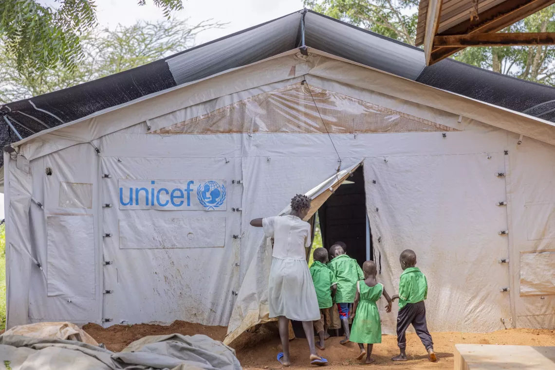 A caretaker walks Early Childhood Development (ECD) resettled children to class at Loodoi Primary School in Napak District, Karamoja sub-region.