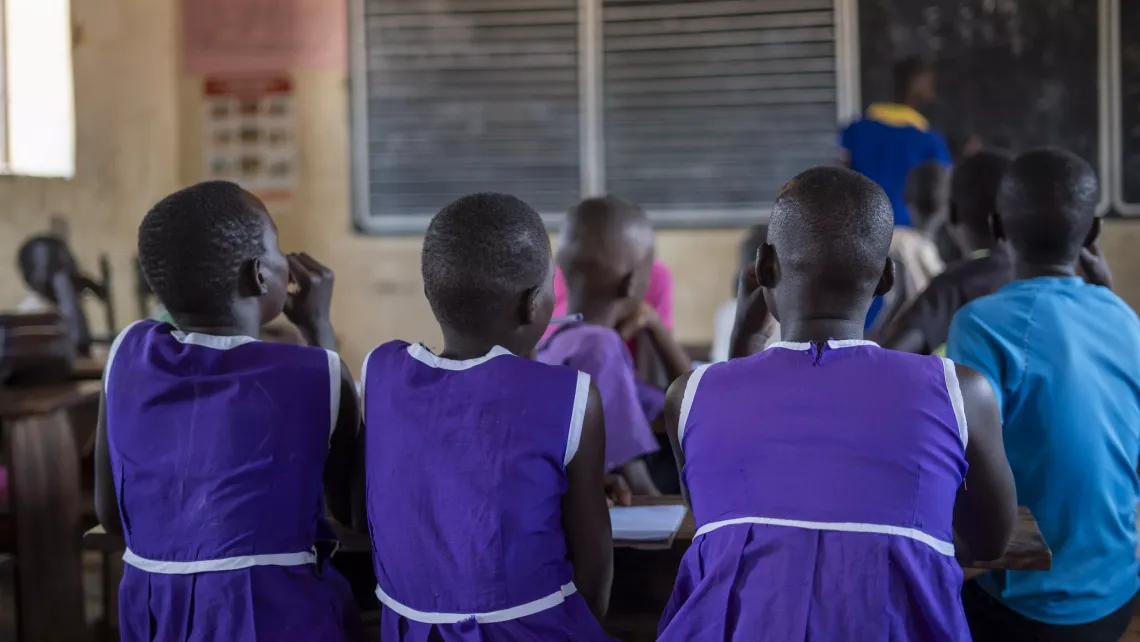 Hope, 13, attends a lesson alongside fellow resettled learners at Lokodiokodioi Primary School in Napak District.
