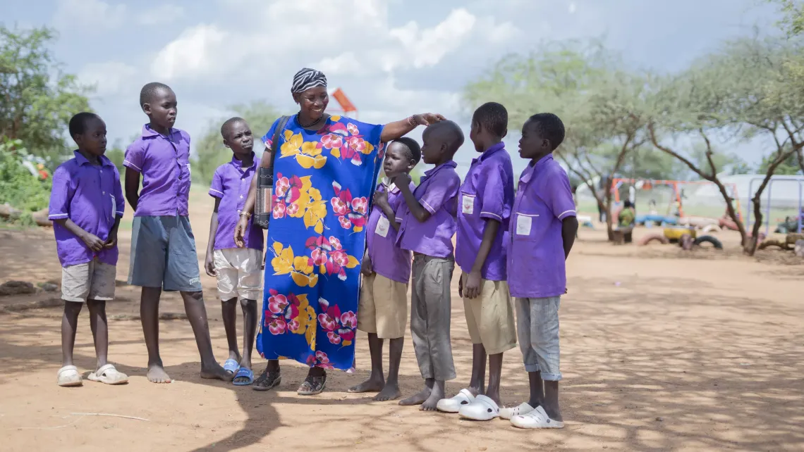 A parasocial worker talks to a group of boys during her routine visit at Lokodiokodioi Primary School in Napak District, Karamoja sub-region.