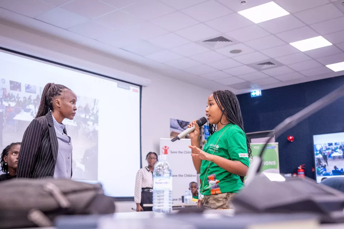 A child participant takes the microphone to share her perspective during the National Children Climate Dialogue held at UNICEF Uganda offices in 2025. 