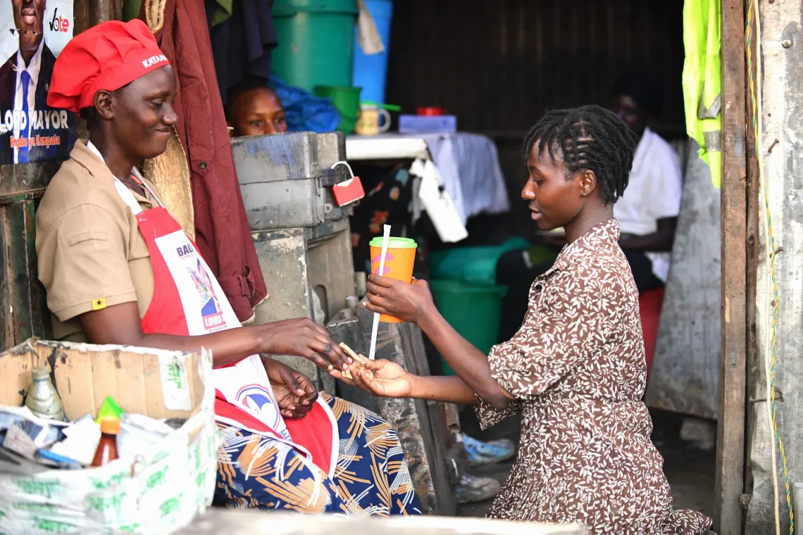 Ndibalekera Maria Judith, one of the beneficiaries of the Girls Empowering Girls program, sells fresh juice made from her small fresh juice business at home to the neighbors in Kisenyi Zone in Kampala. 
