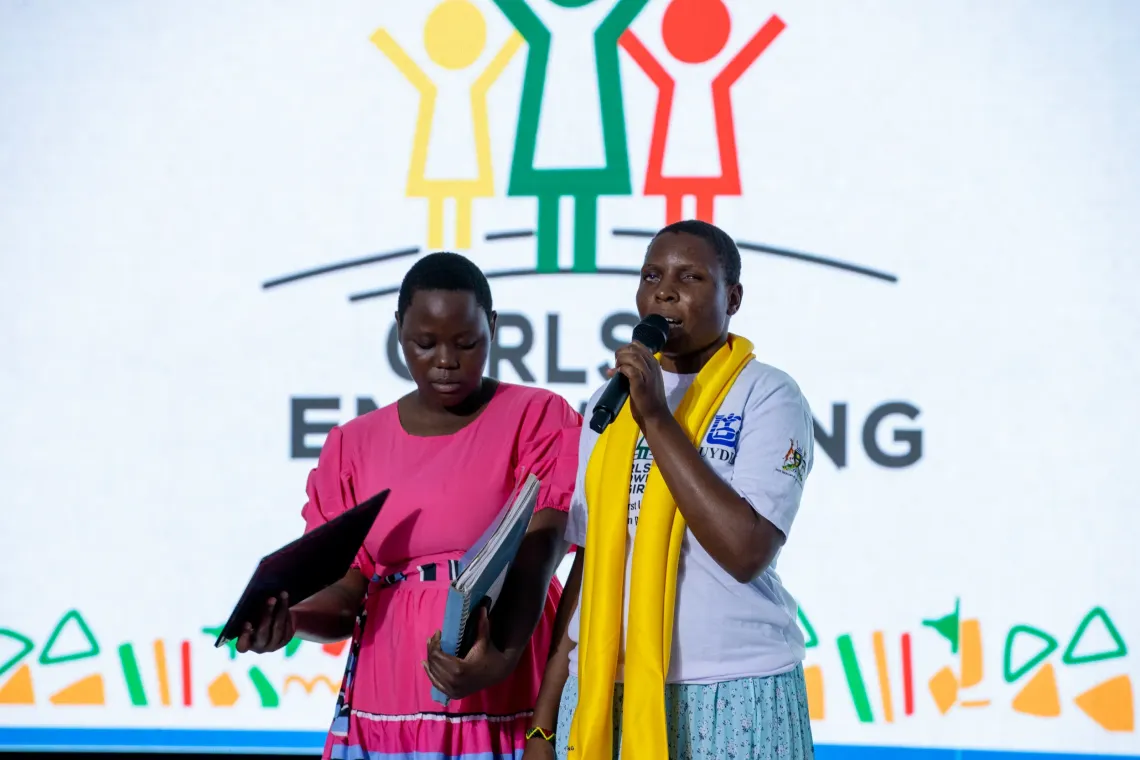 Two girls make a presentation at the close-out of the Girls Empowering Girls programme, City Hall, Kampala, 17 April 2026. For many beneficiaries, finding their voice was as significant as the cash transfers and mentorship. As one put it, the programme allowed her to stand and share her story, something she once thought she could never do.