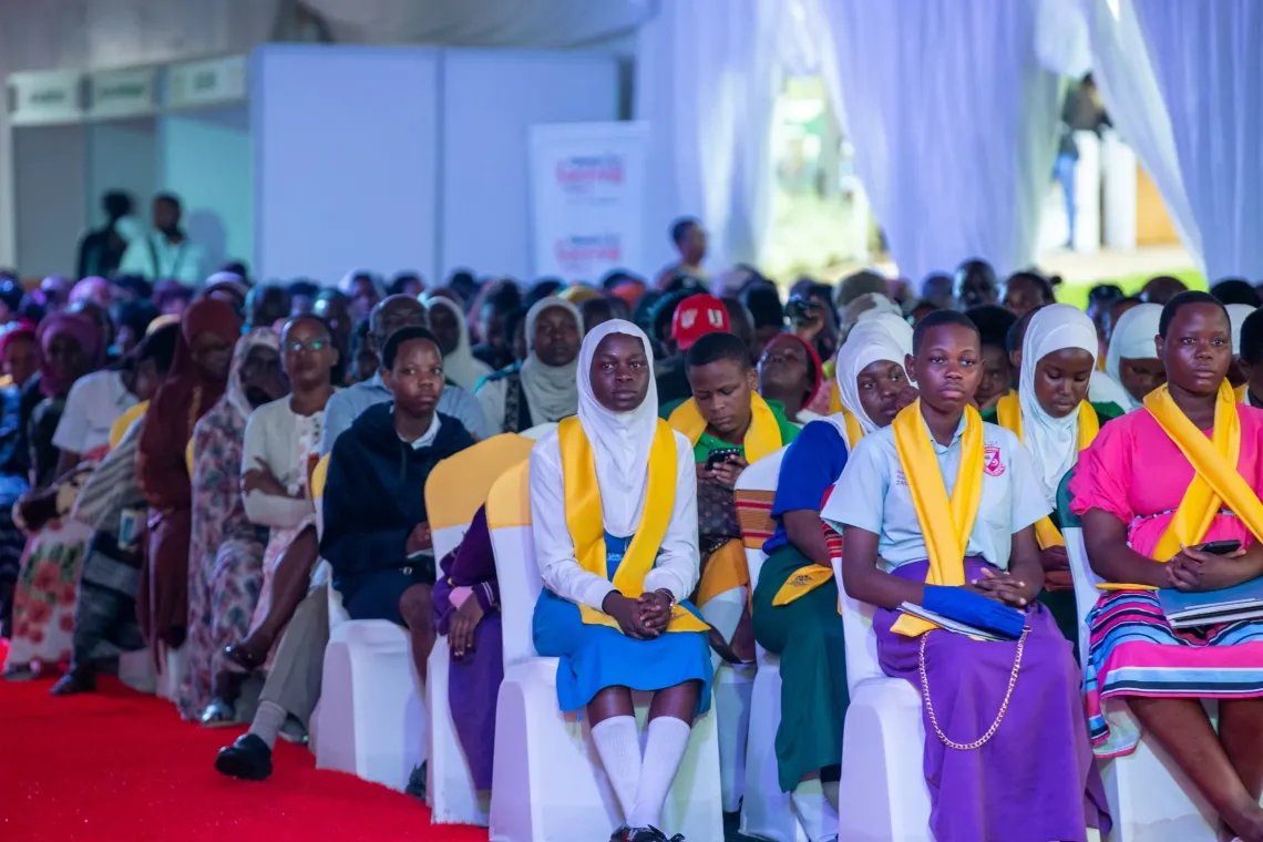 Adolescent girls sit shoulder to shoulder at the High-Level Close-Out Event for the Girls Empowering Girls programme, City Hall, Kampala, on 17 April 2026. For six years the programme reached more than 4,150 girls in settlements such as Kisenyi, Kabalagala and Lungujja, helping many return to and stay in school. 