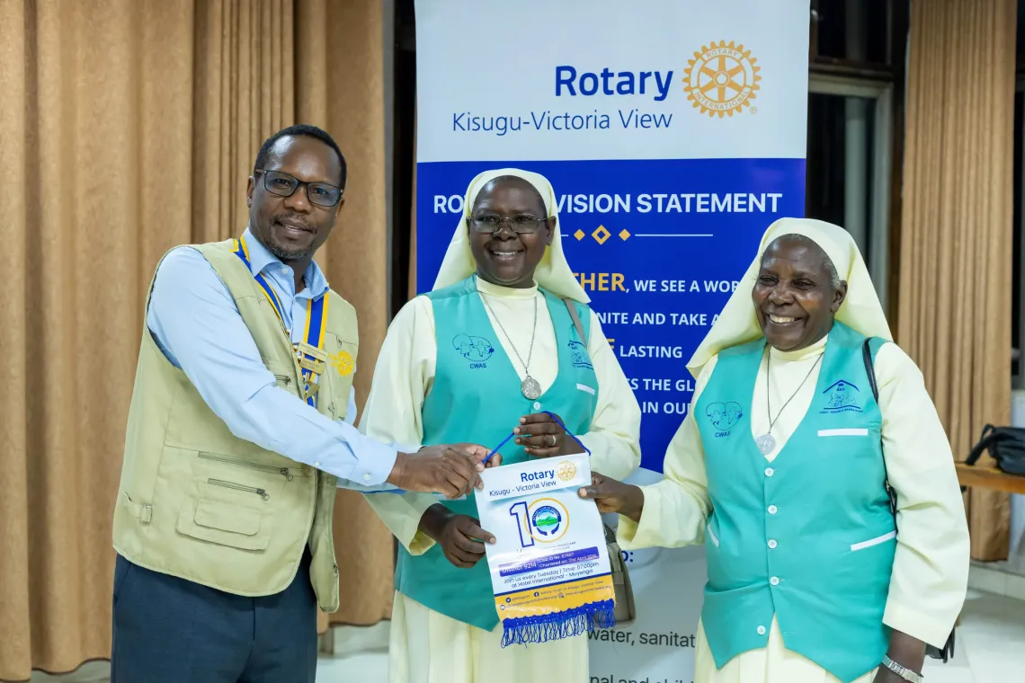 Bernard Tabaire (L), President of the Rotary Club of Kisugu Victoria View, presenting a rotary badge to sisters from Nsambya Babies' Home during the inaugural fellowship of the Rotary Club of Kisugu Victoria View for the 2026/2027 Rotary year at Hotel International Muyenga in Kampala, Uganda, on July 7, 2026.