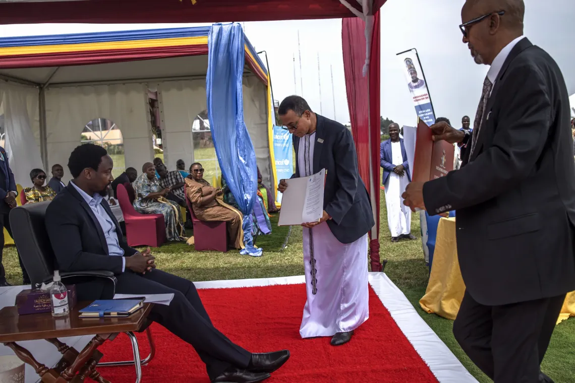 Dr. Robin Nandy, UNICEF Uganda Country Representative, and Owek. Al-Hajj Ahmed Osman Noor, Deputy Prime Minister and Head of Partnerships for the Busoga Kingdom, present the signed Memorandum of Understanding to His Majesty William Wilberforce Kadhumbula Gabula Nadiope IV, the Kyabazinga of Busoga, during the UNICEF Uganda and Kyabazinga Initiative partnership event at Igenge Palace in Jinja, Uganda, on August 7, 2026. 
