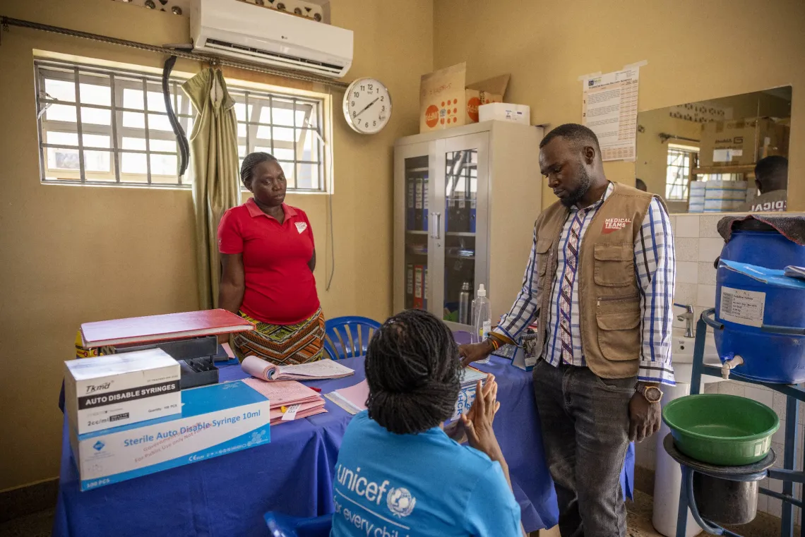 Paska Aluba, Nutrition Specialist with UNICEF Uganda, Vincent Kasule, Nutrition Focal Person at Uriama Health Centre III, and Stores Assistant Susan Karungi interact at the facility store in Terego District, Uganda.