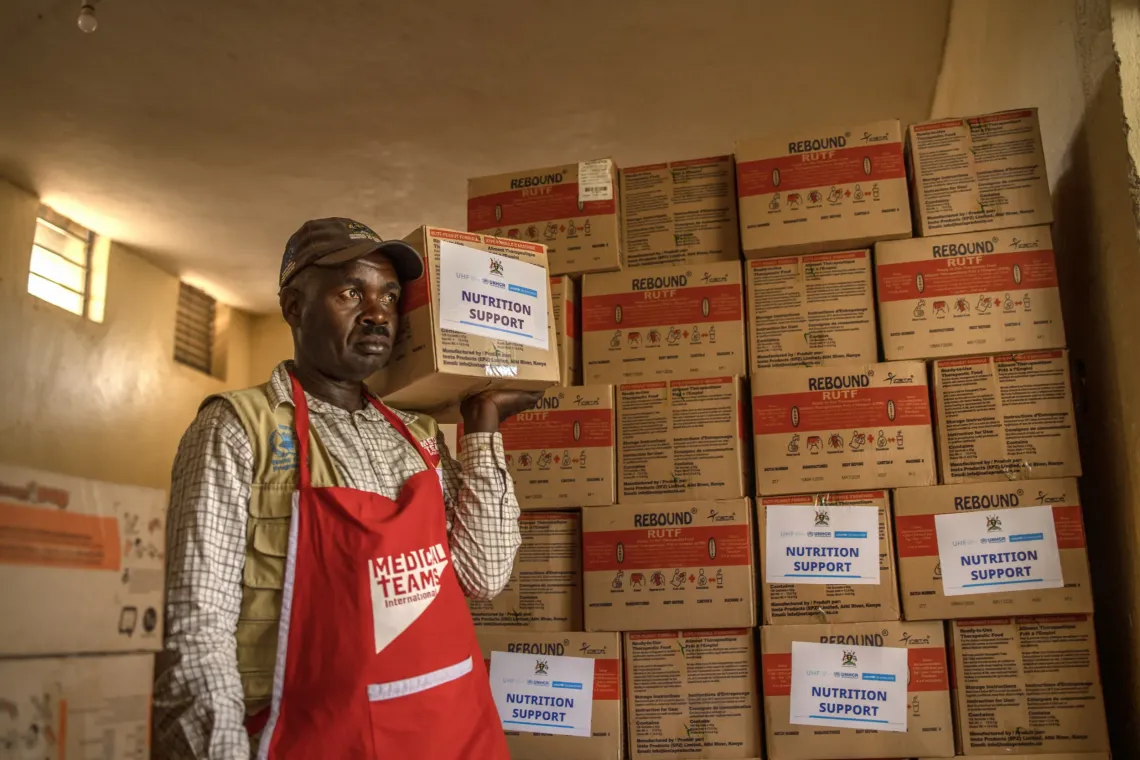 Albert Mwizerwa, 52, a health educator at Nyarugugu Health Centre III, carries ready-to-use therapeutic food (RUTF) from the facility store for distribution to caregivers in Nakivale Refugee Settlement, Isingiro District, Uganda, on September 8, 2026.