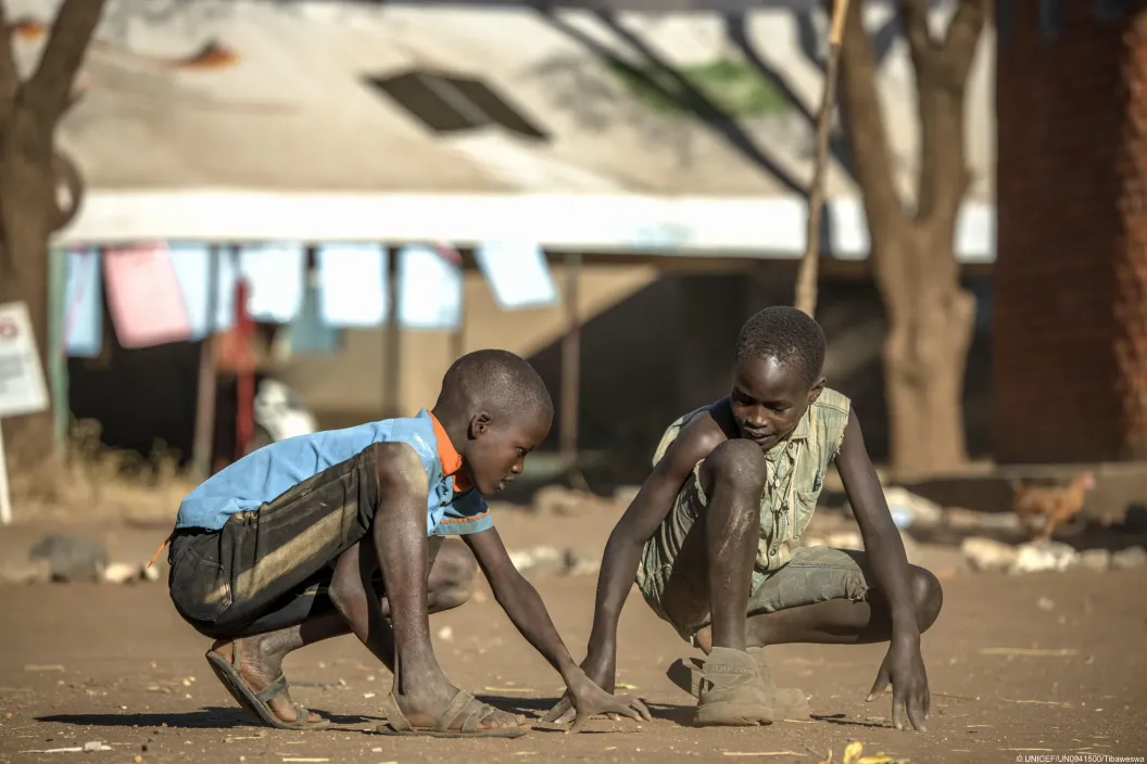 Jonathan Morli (R) and Timothy Gumes (L), students at Rupa Primary School, play a traditional game after classes in Moroto District, Uganda, on September 28, 2026.