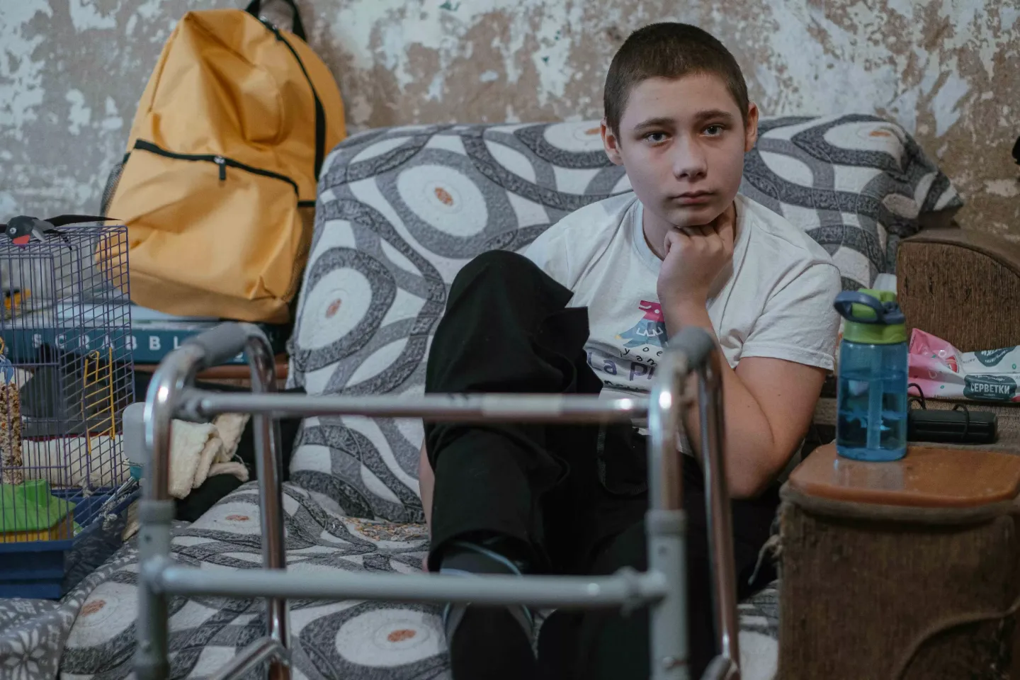Nazar, 13, an explosion survivor, sits next to rehabilitation walkers