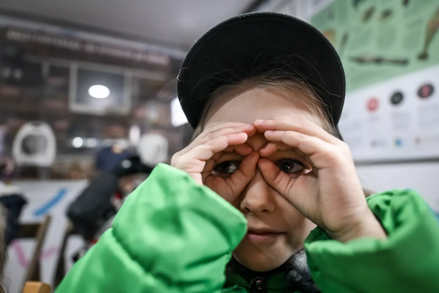The girl looks into her fists like binoculars