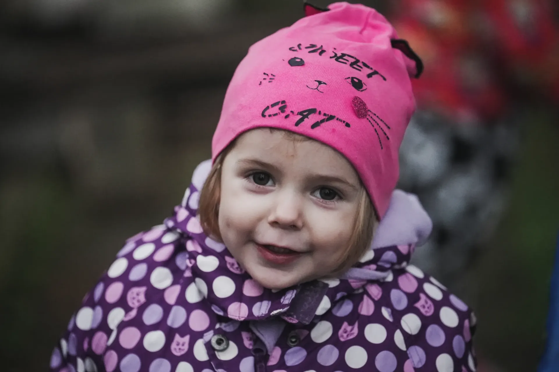 Two-year-old Veronika stands near her home