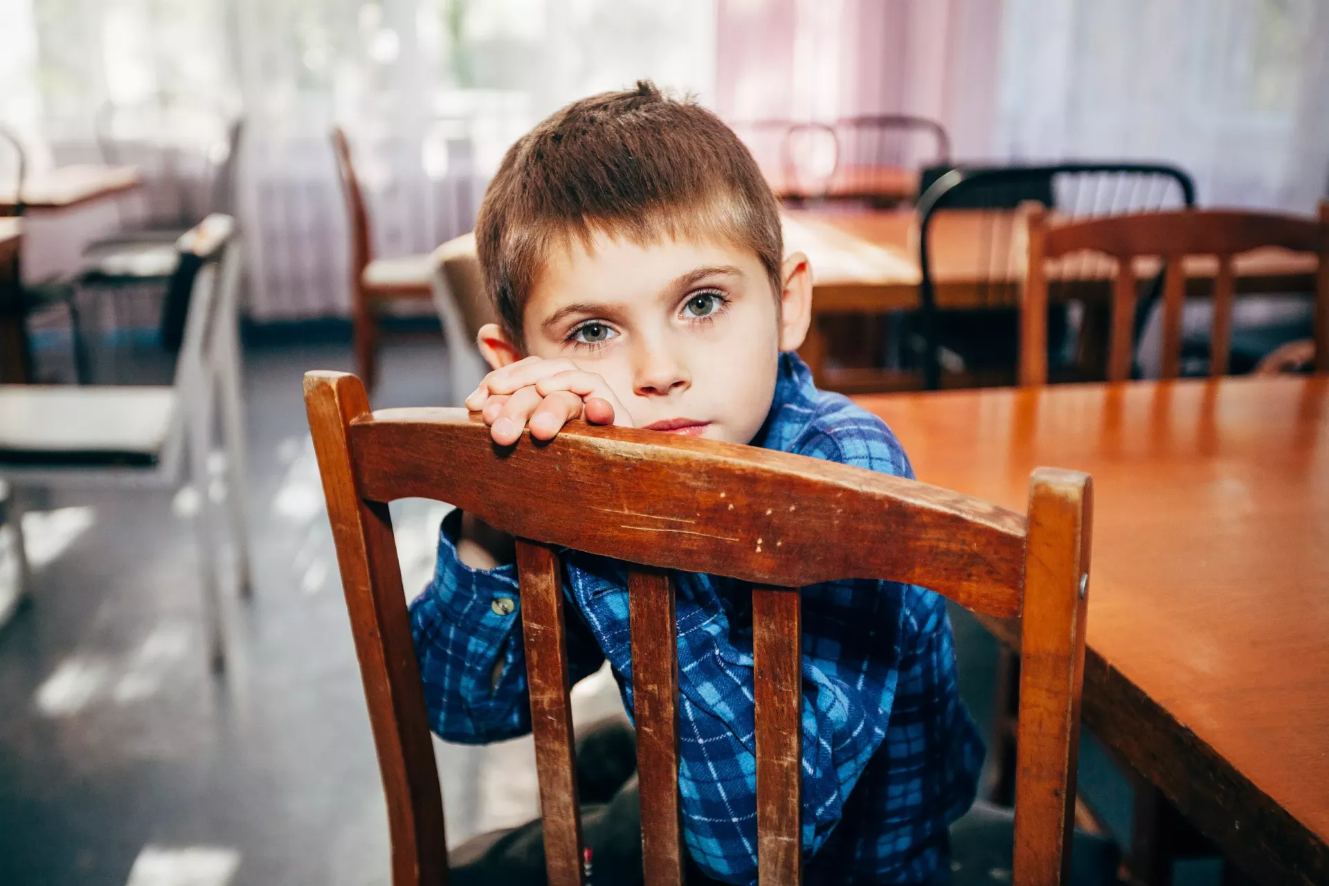 Хлопчик сидить на стільці