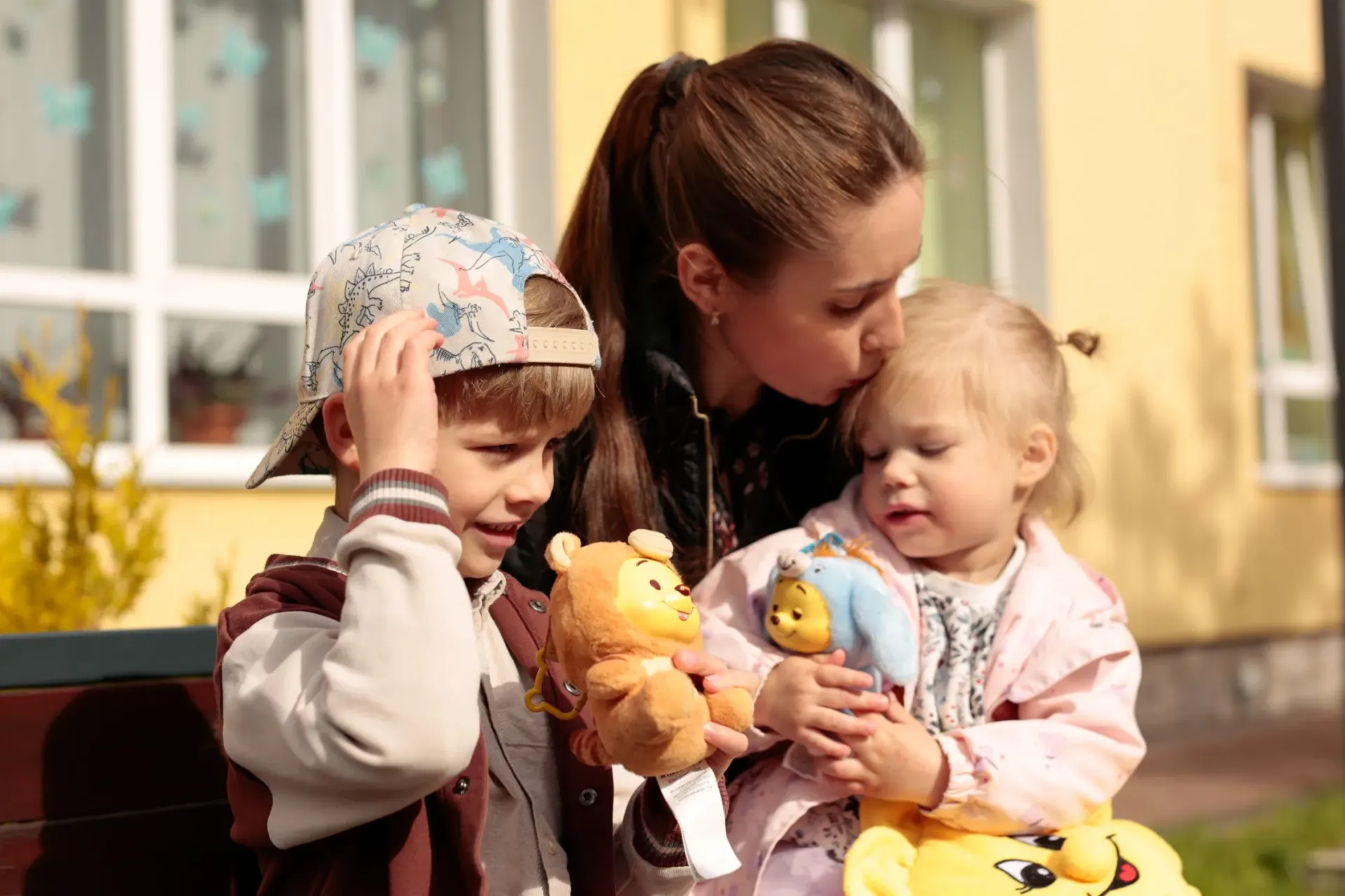 Mother with her two small children near kindergarten in Ukraine