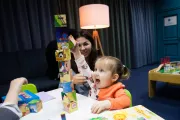 Дворічна Кароліна разом зі своєю мамою будує вежу з кубиків.