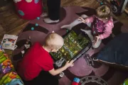 Seven-year-old Denys and three-year-old Sonia sit on the floor playing with toys.