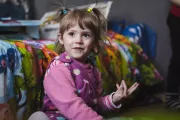 Three-year-old Sonia sits in her room.