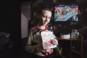 Eight-year-old Matvii shows drawings and crafts he made at school in his room.