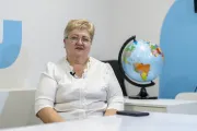 Teacher sitting in the classroom, with a globe on the background.