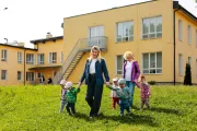 Daycare teacher walks holding hands with children
