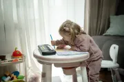 Two-year-old Eva is drawing with pencils at home
