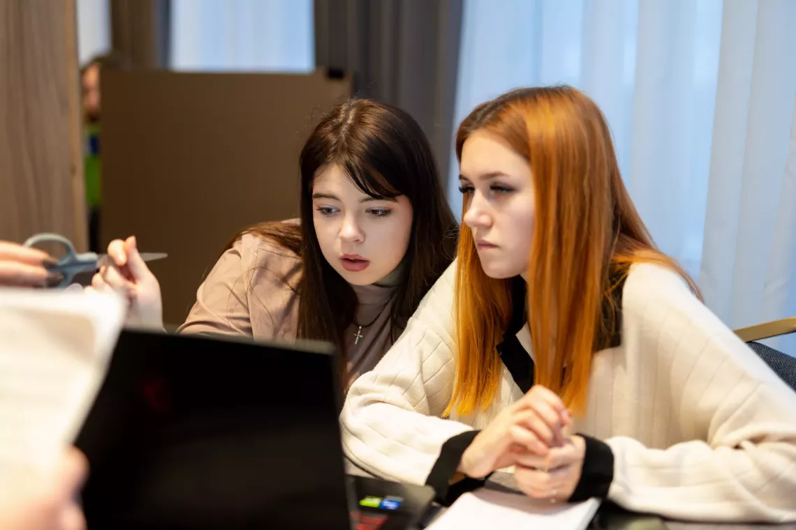 Kateryna and her teammate Myroslava are developing a project idea on a laptop