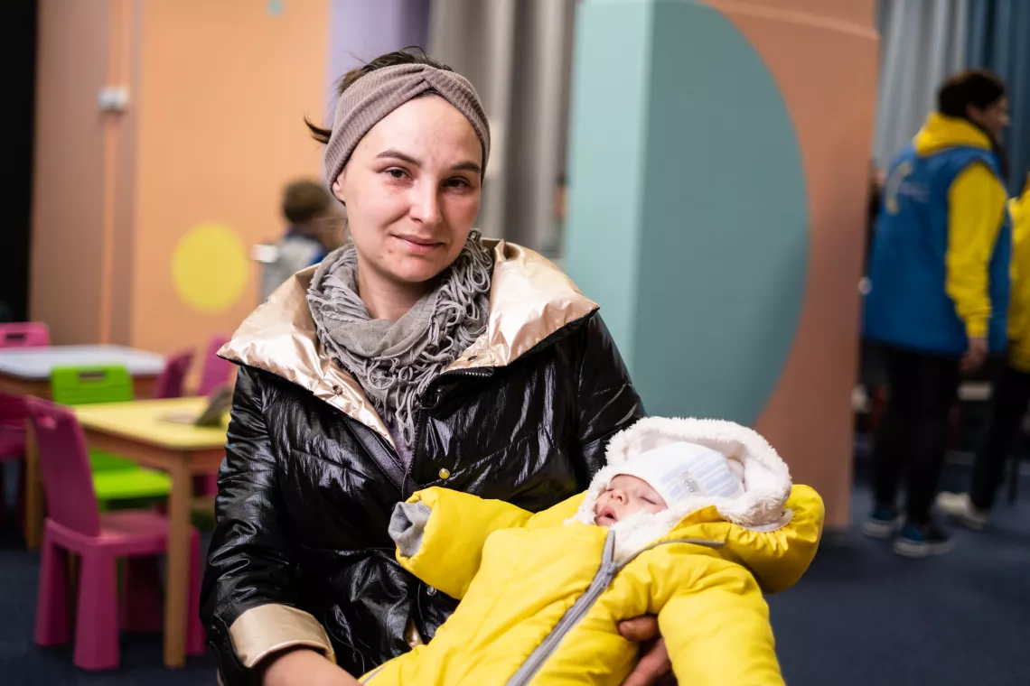Two-month-old Vasyl sleeps in the arms of his mother Olena