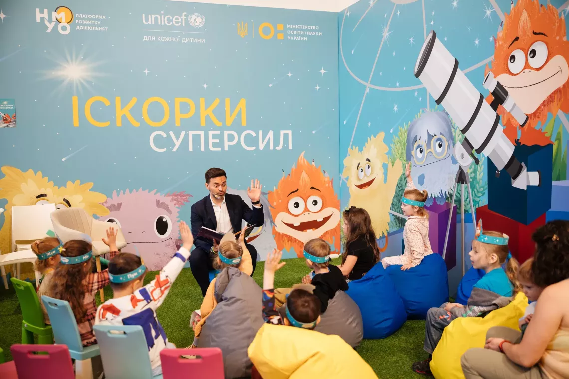 Тимур Мірошниченко читає книгу про Іскорки Суперсил маленьким глядачам на Книжковому арсеналі