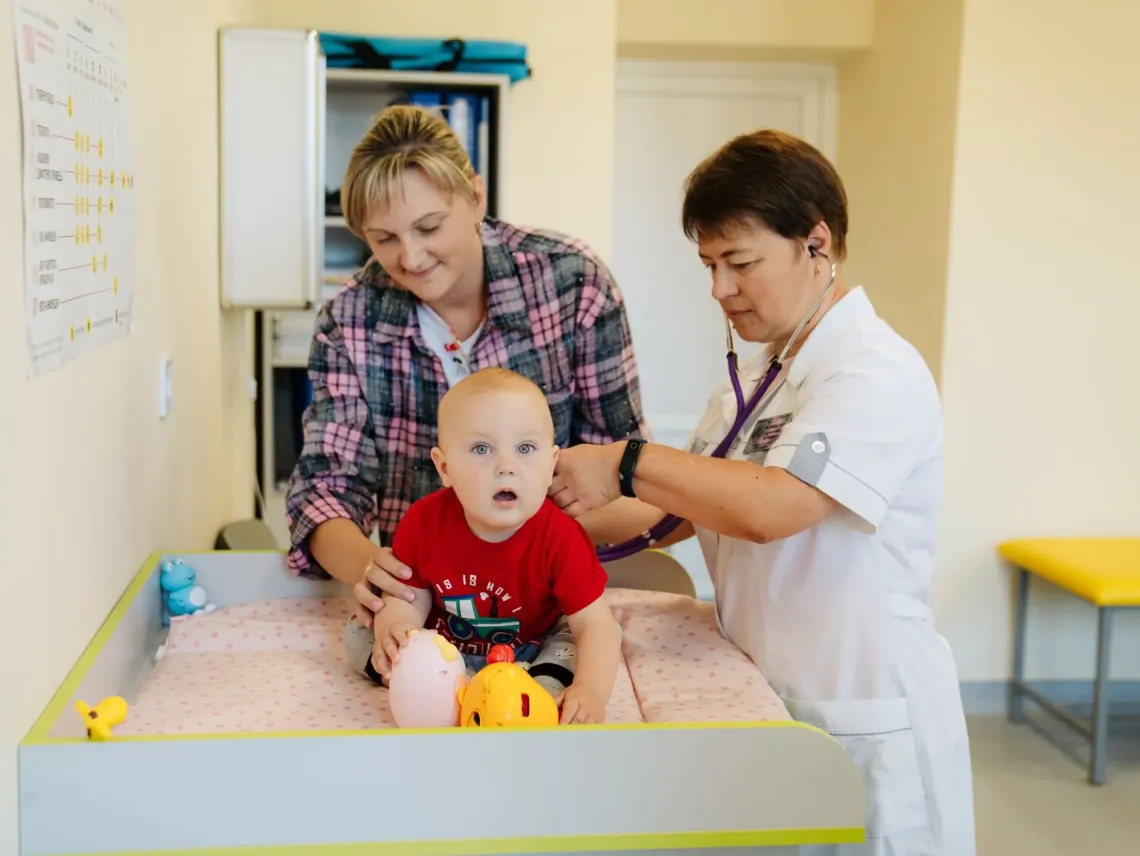 A doctor is checking on a baby boy at the hospital.