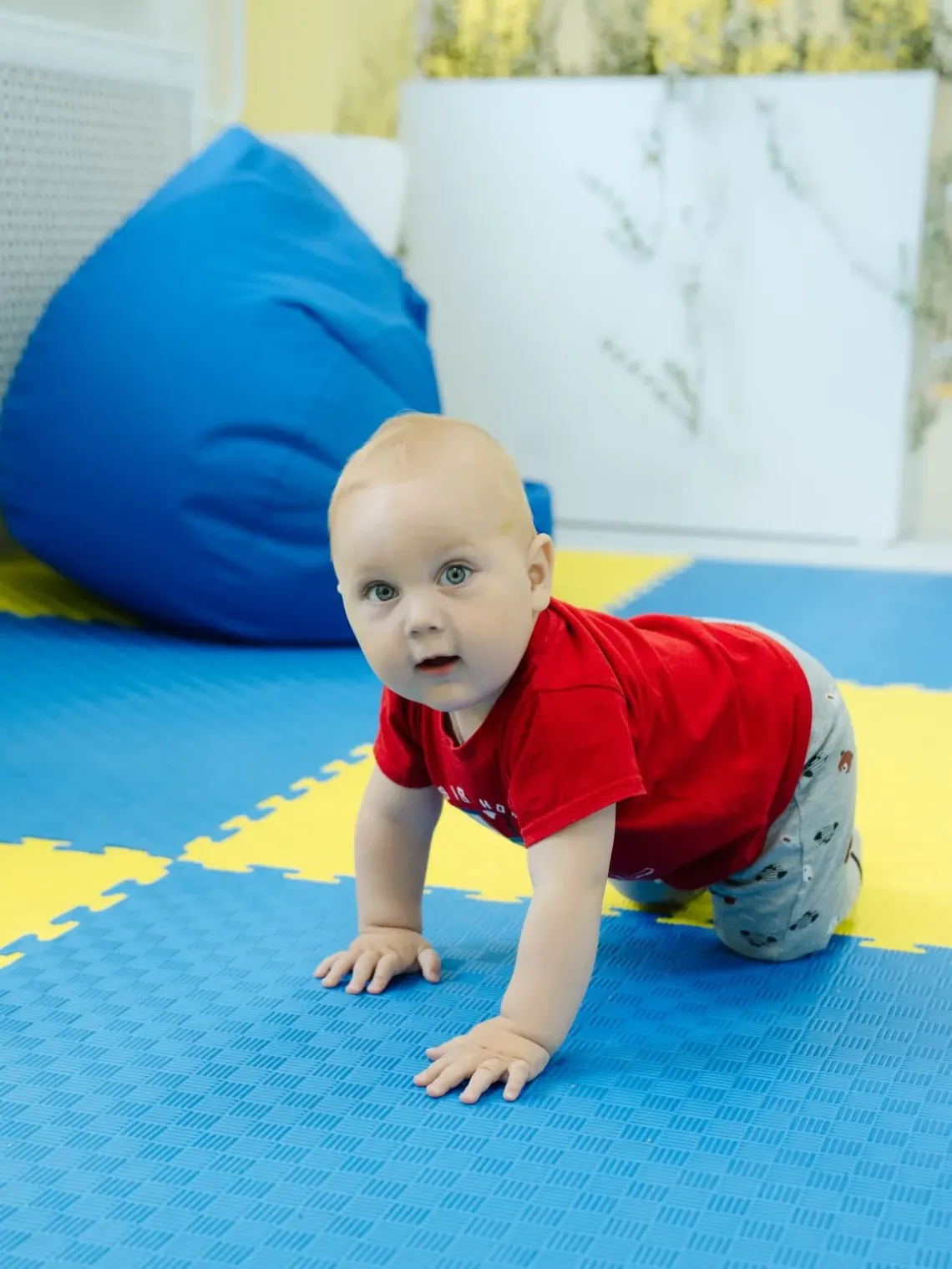 a baby boy is growling on the floor.